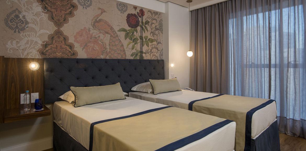 Hotel Luzeiros Ресифи Экстерьер фото The photo shows a modern bedroom featuring two single beds that are neatly made with light-colored blankets and decorative pillows. The headboard of the beds is upholstered in a dark material, giving it a stylish appearance. Behind the beds, there is